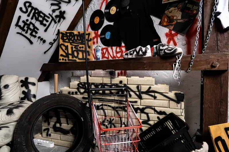 Opony i wózek sklepowy na tle graffiti w strefie Bronx