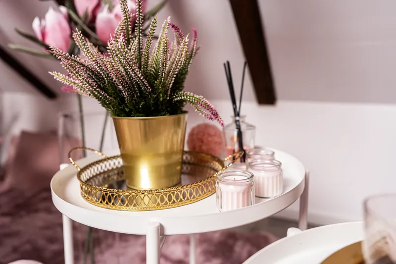 Złoty wazon i różowe dodatki na stoliku w scenografii Pinky Pinky