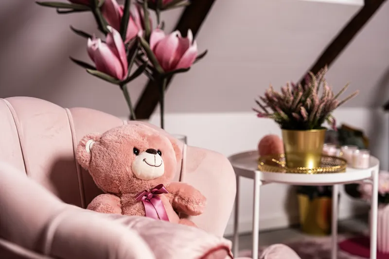 Różowy fotel z pluszowym misiem w scenografii Pinky Pinky